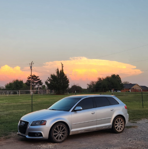 A silver car against a sunset.